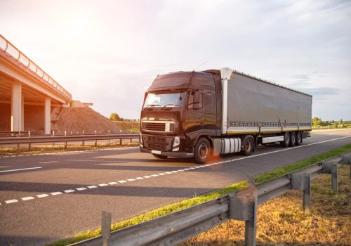 A,Black,Modern,Truck,With,A,Semi-trailer,Is,Driving,Along