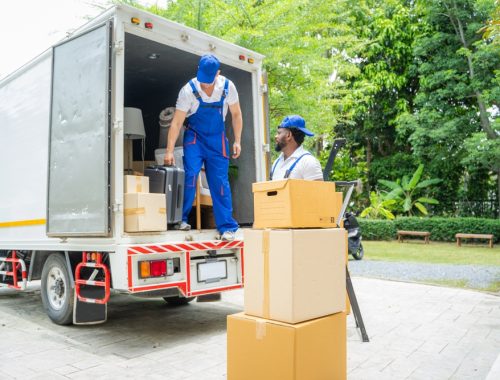 Removal,Company,Workers,Unloading,Boxes,From,Truck,Into,New,Home